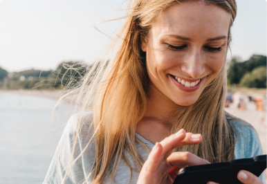 A smiling woman using a smart phone