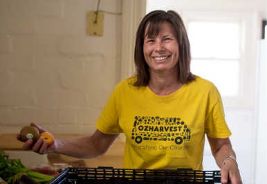 A woman wearing an Oz Harvest shirt